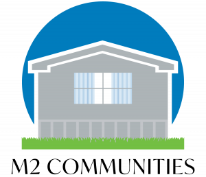 Logo of an MHC Company with a grey house, blue sky and green grass