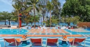 Beachfront area of Courtyard by Marriott Phuket, Patong Beach Resort with guests enjoying ocean views and direct beach access.