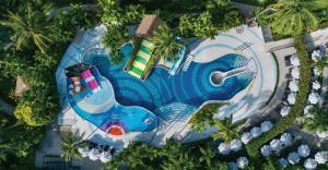 Family enjoying the Fun Pool at Courtyard by Marriott Phuket, Patong Beach Resort with slides, water features, and play areas.