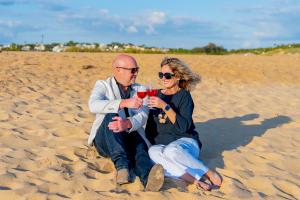 Sarah Hampel with her husband Damien on a European beach, smiling and celebrating the lifestyle freedom achieved through Prosperity Of Life.