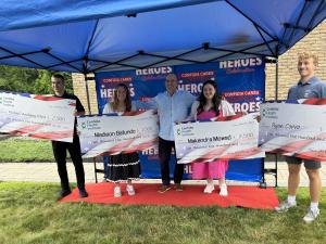 Dr. Kevin Greene of Confidia Health Institute stands with four scholarship recipients in front of the Confidia Cares: Honor Our Heroes backdrop during the Alumnus Scholarship Ceremony.