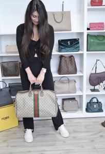 Lena holding Louis Vuitton Designer Handbags. Buying and selling designer handbags brands Louis Vuitton, Chanel, Goyard, Hermes', Prada, Gucci, Tiffany & Co., Burberry, and more.