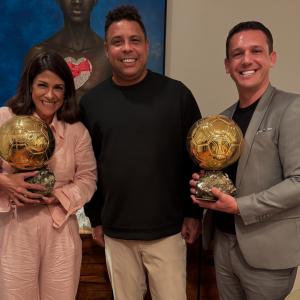 Rony Jabour, Carolline Jabour y Ronaldo Nazário posan sonrientes sosteniendo trofeos del Balón de Oro en São Paulo, Brasil.