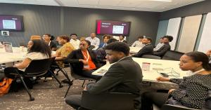 A room full of Black university students in business attire attentively listening during an Onyx Initiative workshop.
