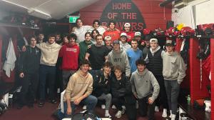 Hockey team posing in a locker room after taking part in a Shiftmakers Tour workshop on inclusion and team culture.