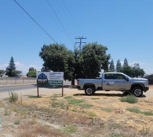 A leader in compliant waste handling, Valley Haul-Off LLC is redefining what certified hauling and environmental responsibility look like in the Central Valley Valley Haul-Off LLC truck parked next to the company sign, representing certified hauling and eco-friendly waste management in the Central Valley.