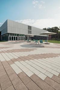 Public Space using Techo-Bloc's Industria HD2 Granitex pavers in Chestnut Brown and Beige Cream arranged in a large-scale floral motif