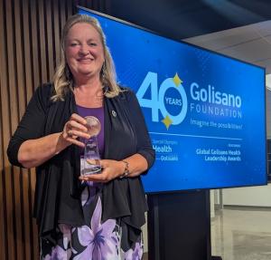 Dr. Kellye Knueppel receives Golisano Health Leadership Award. Pictured holding the award.