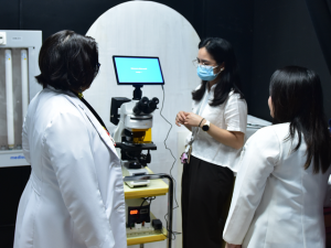 Philippine Dermatological Society President Dr. Jasmin Jamora examines LED fluorescence microscope donated by Rotary Club of New Manila East and Rotary Club of Daejeon Jungdo to QMMC for advanced skin disease diagnosis and dermatology training.