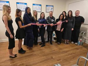 Lindenhurst Cosmetology students Allie Ehrlinger, Gianna Aiello, Charlie Franklin, and Julia Chrzanowska hold the ribbon at the ceremony, with Stephalina Amador, JoMarie, Marissa Fors, Dean Riskin, and Suzanne Chimera performing the ribbon cutting from left to right.