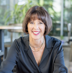 Anne Roche, transformational life and leadership coach, smiling confidently outdoors. She celebrates 10 years of coaching and prepares to release her 2026 book, “Transform Your Life without Blowing it Up.” Photo courtesy of Anne Roche, photographed by Pri