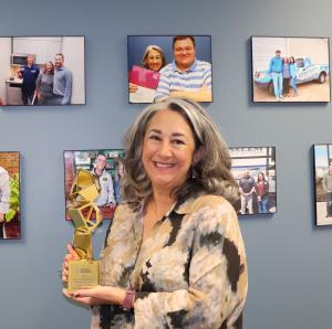 Tanya H. Miller, President of Secret Weapon Media Agency in Madison, Alabama, holding a Davey Award for excellence in video production