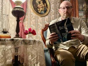 Dr. Chad Scott with his book, Beyond the Darkness, at the historic Lizzie Borden House in Fall River, Massachusetts.
