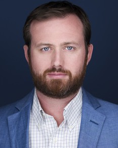 Adam Knox, a male executive in a blue suit