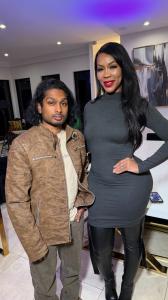 Ashwin Gane standing next to London “Deelishis” Charles both posing indoors in stylish attire with modern lighting and decor in the background.