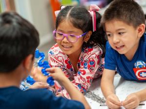 Discovery School of Innovation, a private Kids Holding Parts of a Robot as They Learn to Create Code