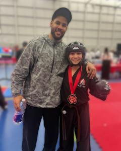 Eli Cooper with coach Devon Hopper after his gold medal point-fighting performance.