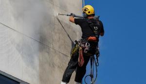 Ein Mann reinigt eine Fassade mit einem Hochdruckreiniger