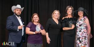 The Arizona Council on Economic Education (ACEE) hit it out of the park at its 12th Annual Champions in Education celebration on Saturday, November 15 Two Arizona Economic Education Teachers of the Year stand smiling at the Champions in Education event, holding their awards in front of a black backdrop.