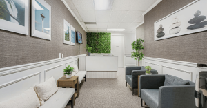 Bright and modern waiting room at Eastside Counseling Center in Bellevue, Washington, with comfortable chairs, natural greenery wall, framed artwork, and a peaceful therapeutic atmosphere.
