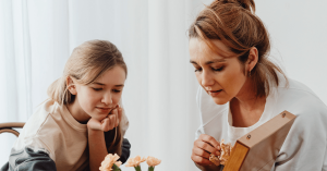 Mother and daughter sitting together in a calm room, talking gently while processing grief — representing family-focused counseling support at Eastside Counseling Center.