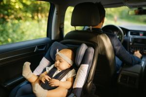 Professional chauffeur driving with a baby safely seated in a car seat, representing Richline Transportation’s family-friendly airport transfer service in San Diego.