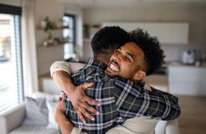 Therapist supporting a young adult during an outpatient rehab and mental health session.