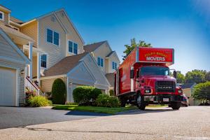 Philip P. Massad Movers Expands Boston Moving Services, Offering Premium Relocation Solutions Across Greater Boston Area 17 Red Philip P. Massad Movers truck parked in front of suburban homes during a residential move in Massachusetts