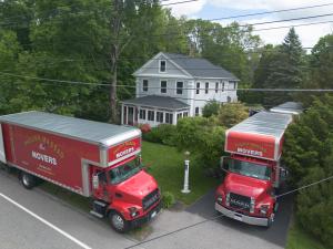 Philip P. Massad Movers Expands Boston Moving Services, Offering Premium Relocation Solutions Across Greater Boston Area 18 Aerial view of two red Philip P. Massad Movers trucks parked in front of a white house during a moving job