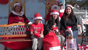 A family taking photos with Santa Claus and Mrs. Santa Claus at LATLC's Comfort & Joy,