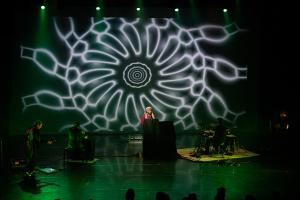 Inglewood Social Club performs in front of a large kaleidoscopic screen.
