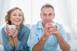 Middle-aged man and woman holding coffee mugs, appearing tired despite normal hormone lab results, illustrating unexplained fatigue in adults