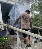 Correira Brothers mover carrying items up outdoor wooden stairs during a residential relocation in Rhode Island