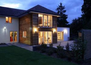 Alt text: house illuminated by lights at night, representing the importance of energy inspections