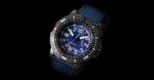 Day view of Luminox ICE-SAR 1080 Series wristwatch with blue dial and blue fabric on top of rubber strap, shown against a black background, featuring high-contrast numerals, rotating bezel, and hands and markers for low-light readability.