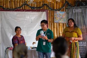 A Love Without Boundaries health promoter demonstrates newborn screening techniques using a training doll while midwives observe.