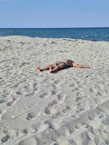 In Zeiten von Billigflieger-Chaos und komplexen Touren kehren Reisende gestresster zurück als je zuvor Mann sonnt sich allein auf langem Sandstrand: Griechenland Reisen weiß wohin – plant nach Wünschen, Kunden reisen bequem und entspannt