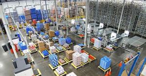 Block One Automation Runs First Unmanned Robotic Shift at Del Papa Distributing 10 Wide view of the main palletizing floor at Del Papa Distributing, showing Block One's Pallet Factory robotic arms and automated systems stacking cases of beer onto pallets inside a beverage distribution warehouse.