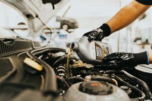 Man adding oil to a car