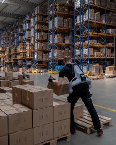 Exia exoskeleton being used for heavy lifting in a logistics warehouse