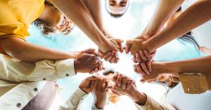 A diverse group of individuals holding hands, symbolizing the community support and financial stability of health sharing membership as an alternative to volatile traditional healthcare markets.