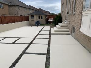 Modern residential concrete patio featuring large slab panels, clean edges, and integrated concrete steps for a sleek backyard design.