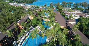 Aerial view of Courtyard by Marriott Phuket, Patong Beach Resort surrounded by lush greenery and turquoise waters.