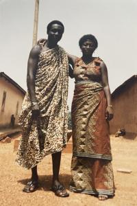 Christabel's Mum and Dad in Ghana wearing West African attire standing with their arms around each other