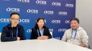 FotoCube founder Matt Wang and hardware partner Mao Qunying during a live media interview at the CES 2026 broadcast studio in Las Vegas, with the FotoCube logo and "Family AI Agent" presentation on the background LED screen.