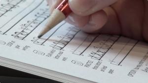 Closeup of student practicing handwriting with a workbook and a pencil