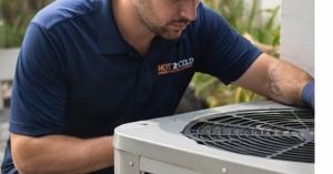 Hot 2 Cold Air Conditioning technician inspecting an outdoor AC unit at a Florida residence