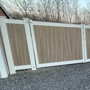 Vinyl privacy fence enclosing a residential yard, featuring white posts and tan panels for a low-maintenance boundary.