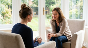 A compassionate therapist engaging in a supportive one-on-one session with a female client in a bright, comfortable outpatient setting at Friendly Recovery Center in Orange County.