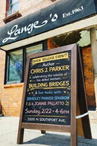 Sign outside Lange’s advertising Chris J. Parker’s “Building Bridges” memoir book release and reading.